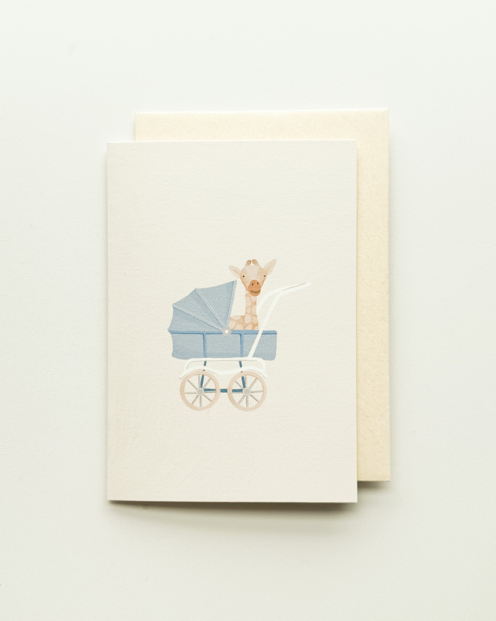 Greeting card with a baby carriage and baby giraffe illustration on a beige background